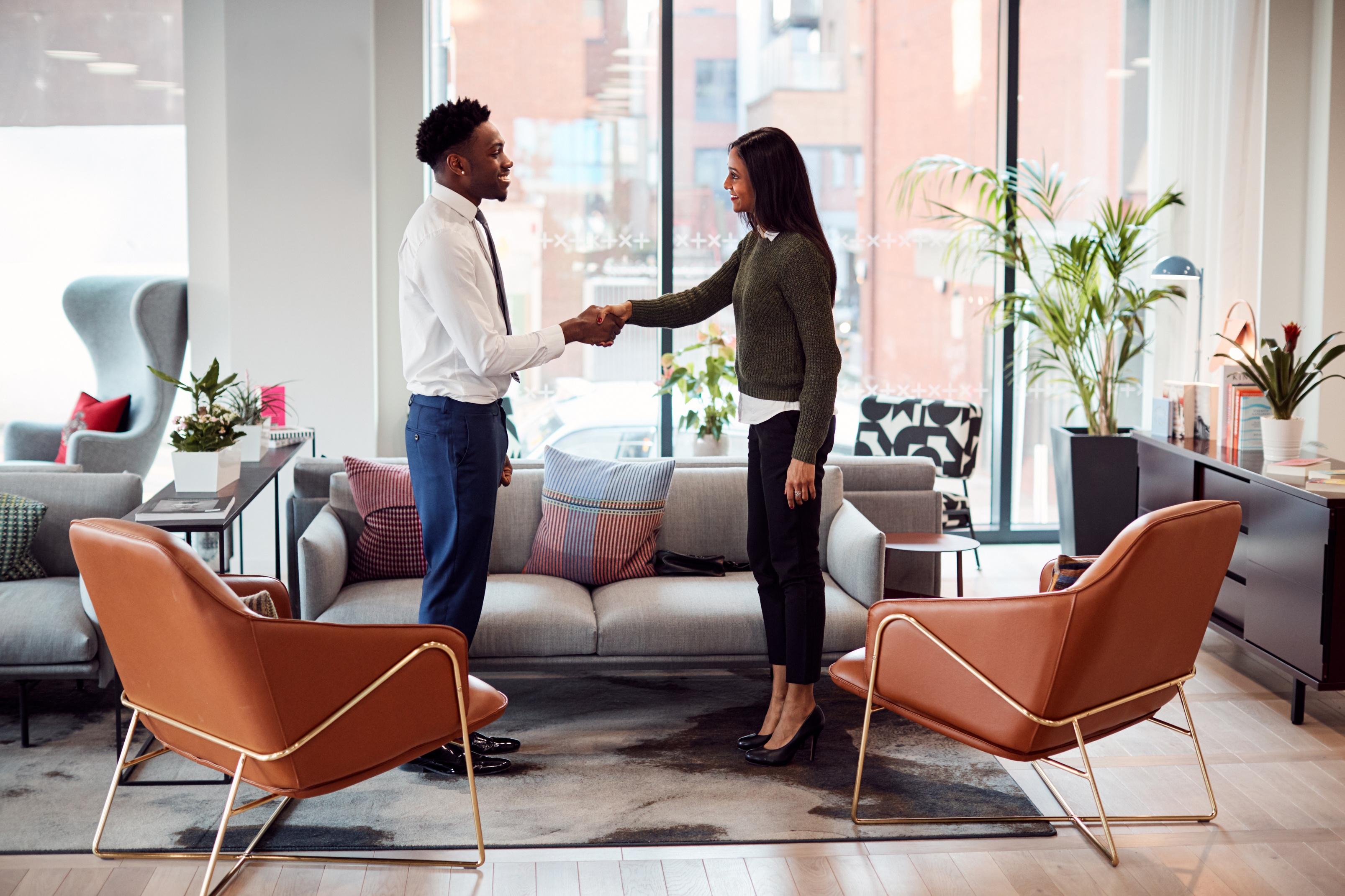 Businesswoman Shaking Hands with Male Interview Candidate